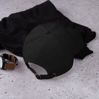Black cap and watch on a textured gray surface