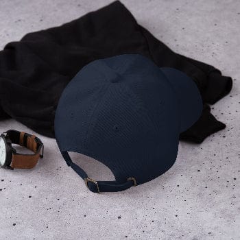 Navy blue cap with a watch and black fabric on a speckled gray surface