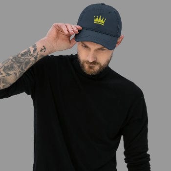 Man wearing a navy cap with a yellow crown logo on a light gray background
