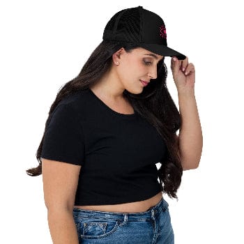 Woman wearing a black cap and black crop top on a white background
