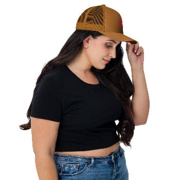 Woman wearing a brown cap, black crop top, and blue jeans on a white background