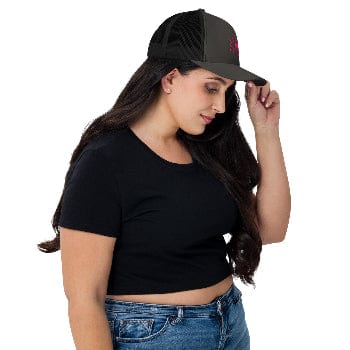 Woman wearing a black cap with a red logo, black crop top, and blue jeans on a white background