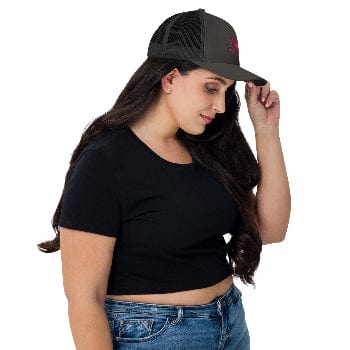 Woman wearing a black cap and black crop top on a white background