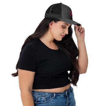 Woman wearing a black cap with a red logo, black crop top, and blue jeans on a white background