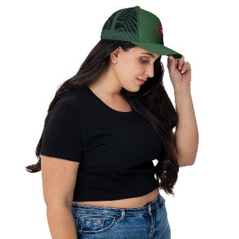 Woman wearing a green cap with a red logo, black crop top, and blue jeans on a white background