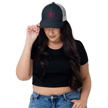 Woman wearing a black cap with a logo, black crop top, and blue jeans on a white background