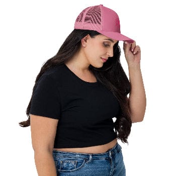 Woman wearing a pink cap, black crop top, and blue jeans on a white background
