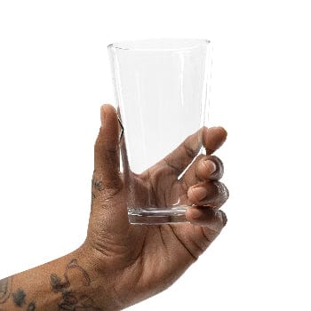Hand holding a clear glass against a white background