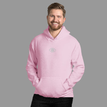 Man wearing a pink hoodie with an eye logo against a white brick wall