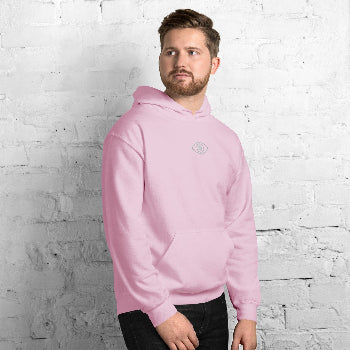 Man wearing a pink hoodie against a white brick wall