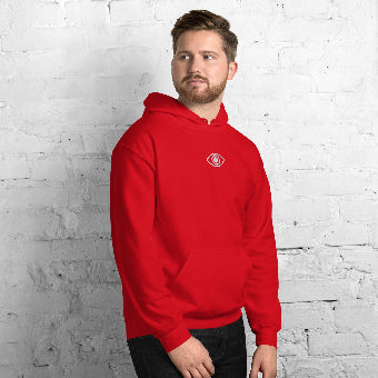 Man wearing a red hoodie with an eye logo against a white brick wall