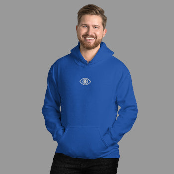 Man wearing a blue hoodie with an eye logo against a white brick wall