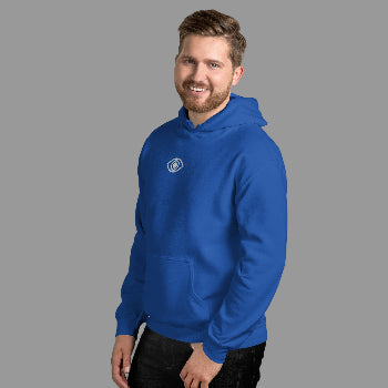 Man wearing a blue hoodie with an eye  logo against a white brick wall