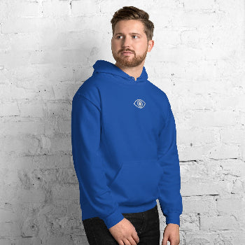 Man wearing a blue hoodie with a logo against a white brick wall